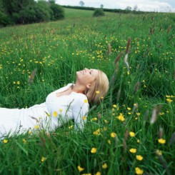 Blond woman lying in field